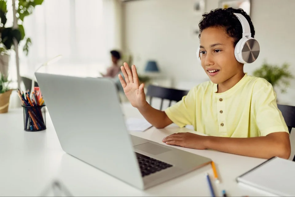 Un enfant portant un casque participe à un cours en ligne.
